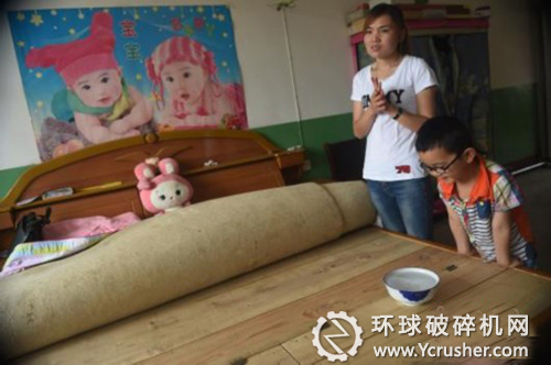 村民将水放在床板上,水面因震动产生水纹