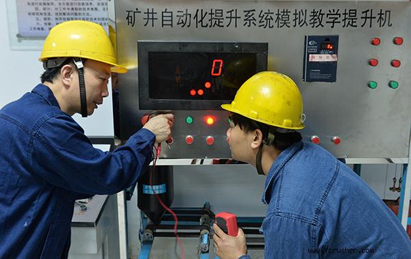 6月3日,在开滦集团林南仓矿业公司矿井主绞车房,刘少辉(左)与工友测试模拟教学提升机数据。